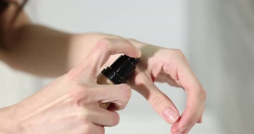 Woman Applying Foundation on Hand for Skin Tone