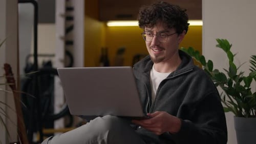 Young Adult Using Laptop Video Call At Home