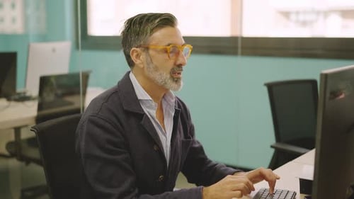 Mature Man Working in a Coworking Desk and Smiling