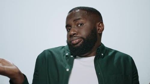 Portrait African American Man Showing Dont Know Gesture in Grey Background. Doubtful