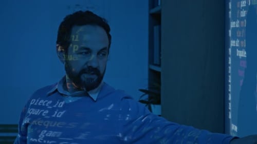 Male Programming Teacher Explaining Computer Code in Blue Projector Light