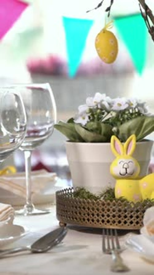 Young Woman Setting Easter Festive Table with Bunny and Eggs Decoration