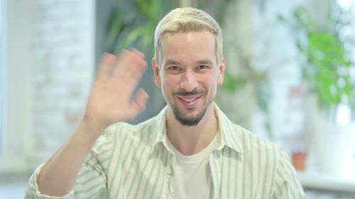 Person Smiling and Waving Hello Indoors