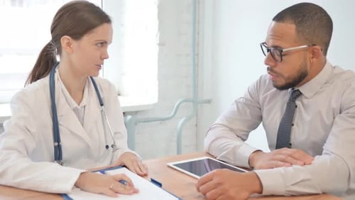 Doctor and Patient Consulting in Clinic Office