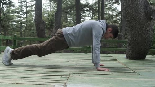 Man Does Pushups in Forest Environment