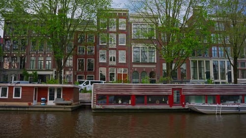Establishing Shot Amsterdam Picturesque Cityscape View Canal with Passing Tourist Boat Old Houses
