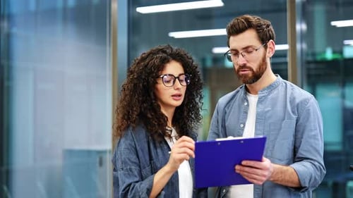 Business Colleagues Discuss a Document in a Modern Office