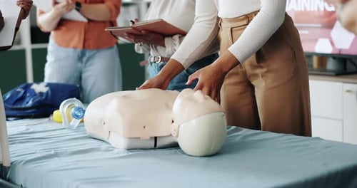 Adults Practicing CPR on Dummy in Workplace