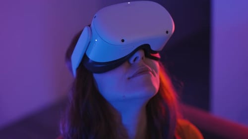Woman Using VR Headset in Blue and Red Lighting