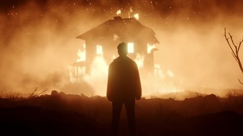 Man Silhouetted Against Burning House at Night