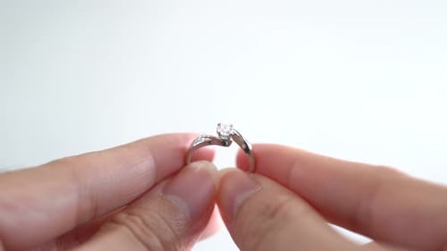 Close up woman pair of hands holding a ring, propose gesture