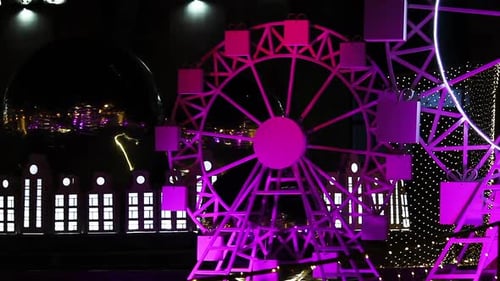 Miniature Ferris Wheel Rotating Against Neon Light In The Dark. close up