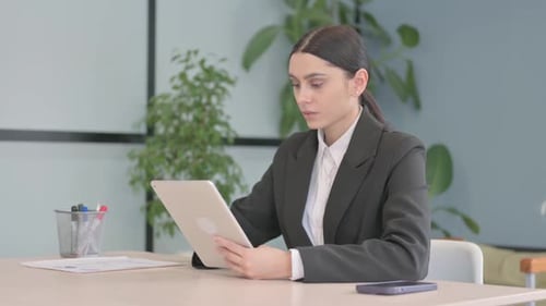 Frustrated Young Woman Using Tablet in Office