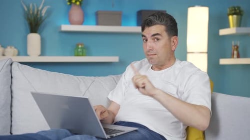Man Working on Laptop at Home on Couch