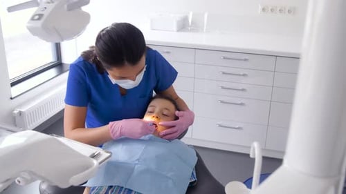 Child Patient Receiving Dental Exam in Clinic