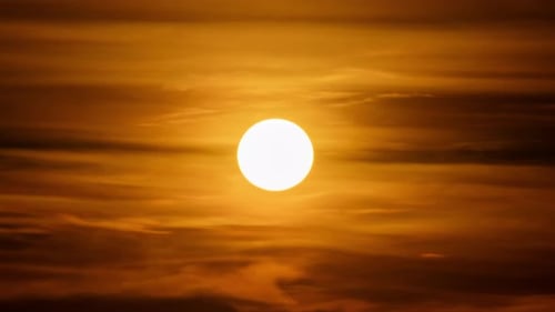 Dramatic Sun Setting Behind Dark Brown Clouds
