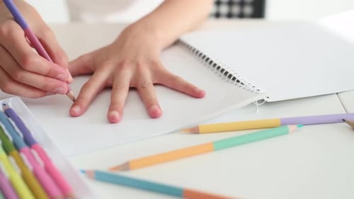 Child Traces Hand with Colored Pencil on Paper