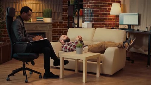 Man Talking With Therapist on Couch in Office