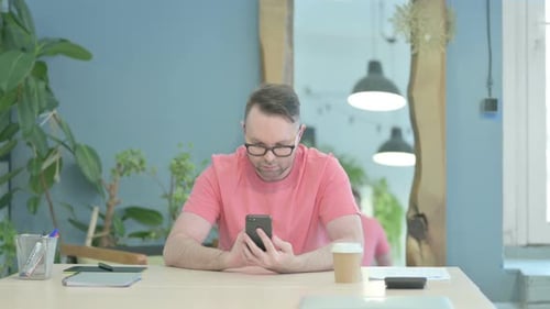 Creative Man Browsing Internet on Smartphone