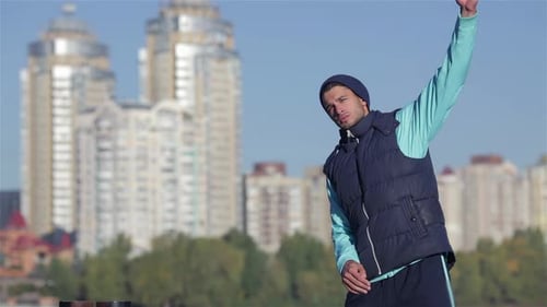 Back View of Fit Men Stretches Muscles Before Morning Jog Outdoors