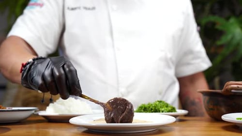 Chef putting beans on top of tortilla in mexican restaurant