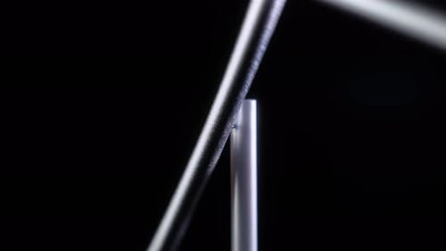 Close Up Minimalist Magnetic Pendulum Balancing on Black Background
