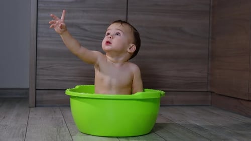 Adorable Baby Bathed in Green Tub