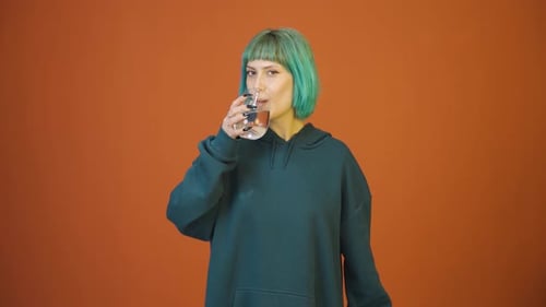 Die junge Frau trinkt Wasser.