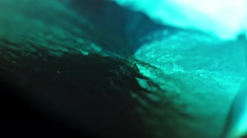 Abstract close-up of turquoise ink diffusing through water, creating vivid, organic patterns