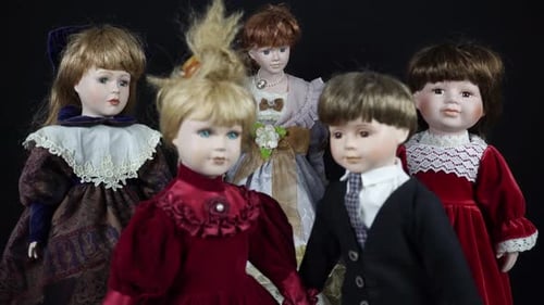 Close Up Of Porcelain Dolls In Beautiful Clothes On Black Background.