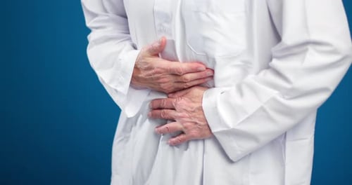 Man in traditional dress experiences stomach pain