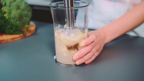 Blending Sauce with a Hand Blender in Kitchen