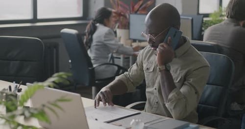 Adult Working in an Office Communicating on the Phone