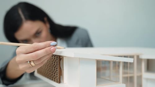 Professional young architect engineer measure house model length. Immaculate.