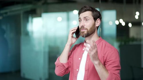 Confident business man entrepreneur freelancer talking on mobile phone at modern office indoors