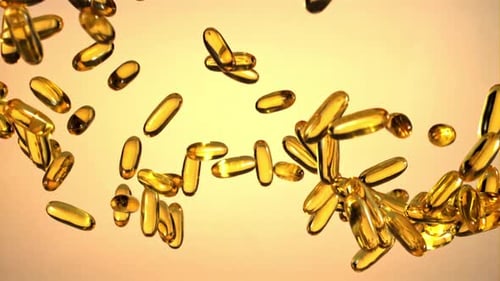 Golden Gel Capsules Floating on Gold Background