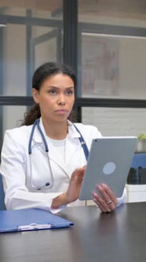 Female Doctor Uses Tablet at Desk in Modern Office