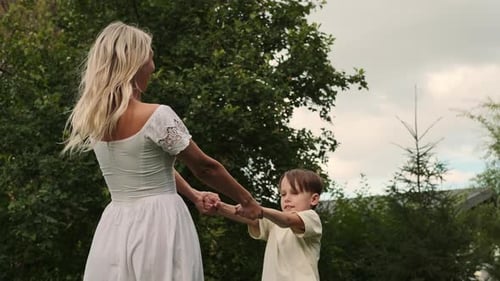 Mother and Child Spinning in a Green Garden