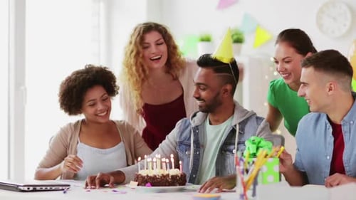 Friends celebrate birthday with cake and party favors