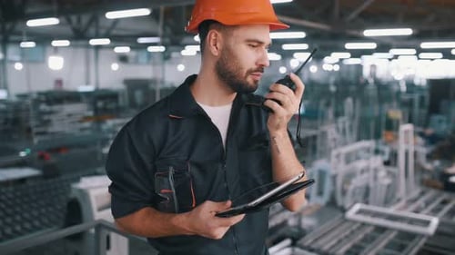 Contractor is with digital tablet. Man is working in the modern factory.