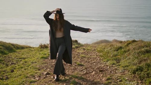 Relaxed Stylish Girl Walking Green Stony Coast at Sunny Autumn Evening. Young