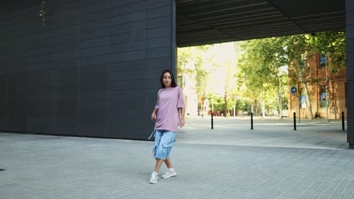 Young Woman Dancing Vigorously on City Street