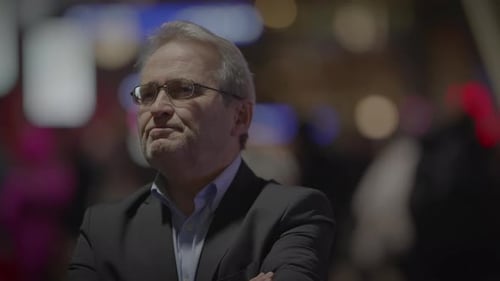 A Contemplative Businessman is Standing in the City at Night Surrounded By Neon Lights