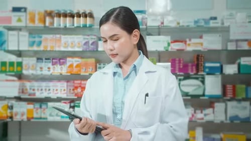 Porträt einer Apothekerin, die in einer modernen Apotheke ein Tablet verwendet