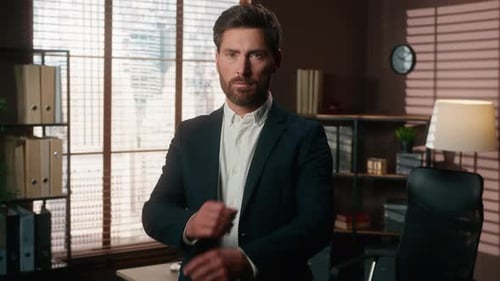 Confident Businessman in Office Setting with Arms Crossed