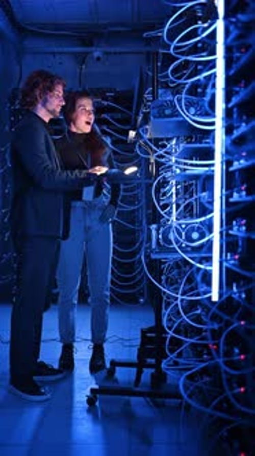 Engineers Inspecting Servers in Neon Data Center