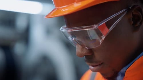 Portrait of Focused Industrial Engineer Working at Modern Factory. Close Up African