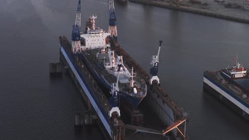 Werft in Riga, Lettland, bei Sonnenuntergang mit Kränen und angedocktem Schiff