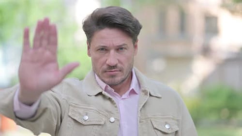 Outdoor Portrait of Disliking Middle Aged Man with Stop Gesture