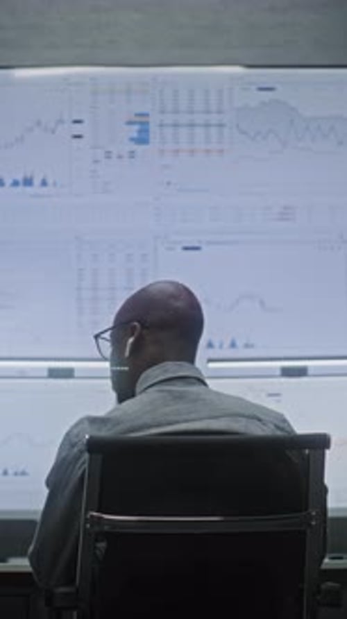 Financial Analyst Working on Computer with MultiMonitor Workstation Monitoring RealTime Stocks